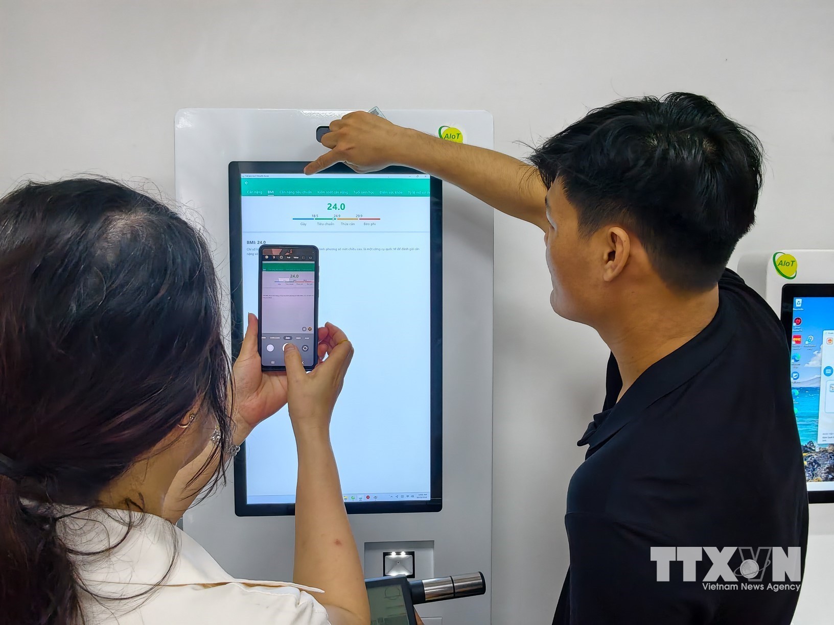 Người dân tìm hiểu tiện ích chăm sóc sức khỏe trên thiết bị số tại Nhà văn hóa Tổ dân phố số 4, phường Giảng Võ. (Ảnh: Trung Nguyên/TTXVN)